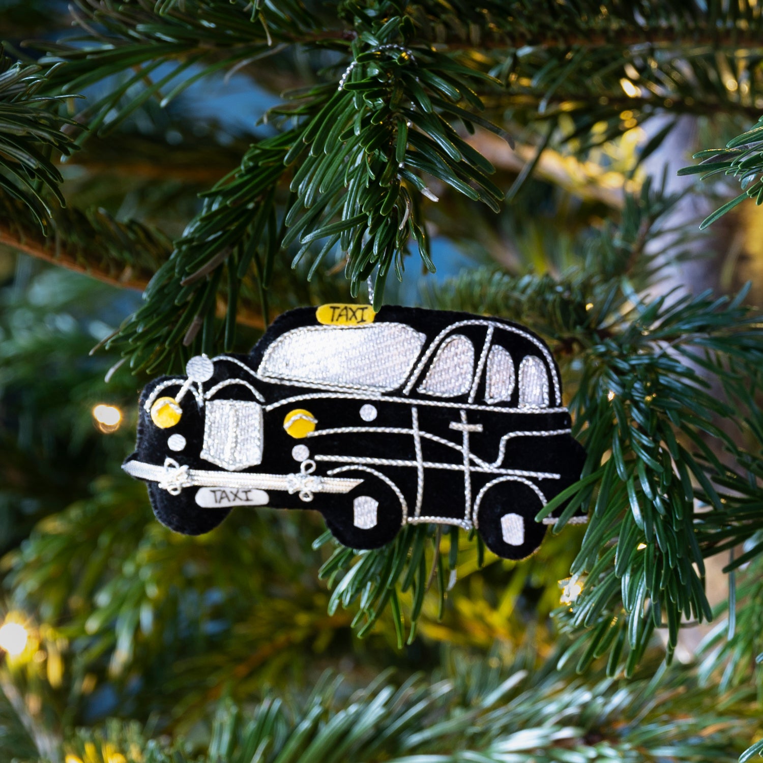 Stitched black taxi decoration hanging from Christmas tree